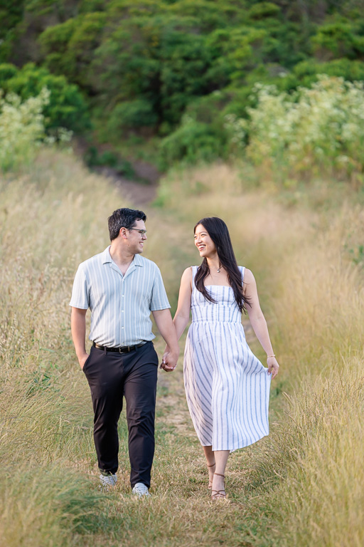 couple walking along a grassy trail