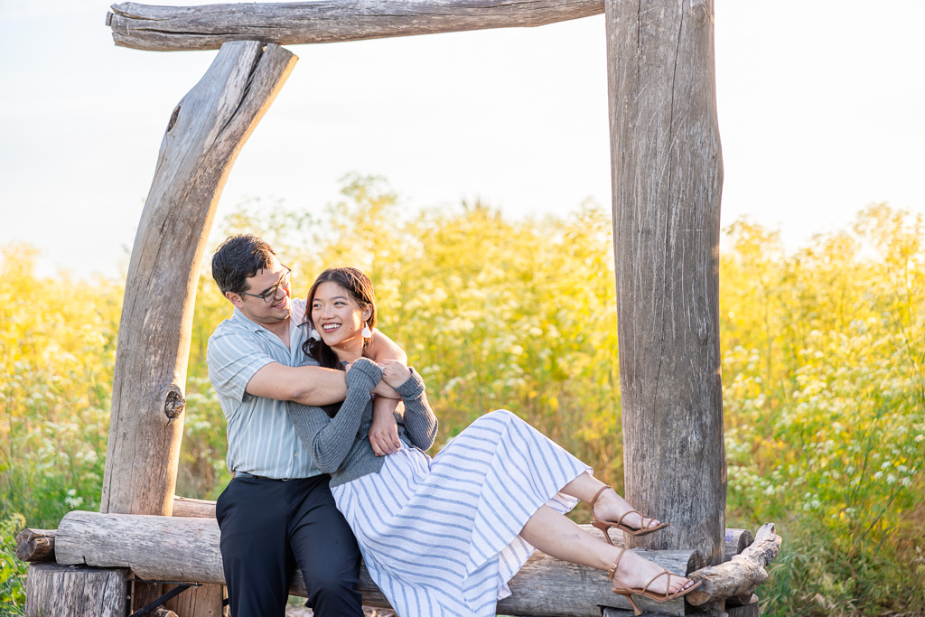 couple leaning on each other on a wooden arbor