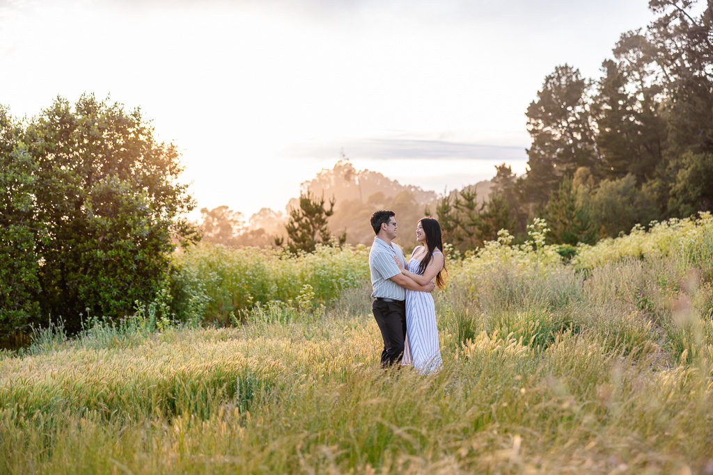 engagement photos in an open grassy field on a hill