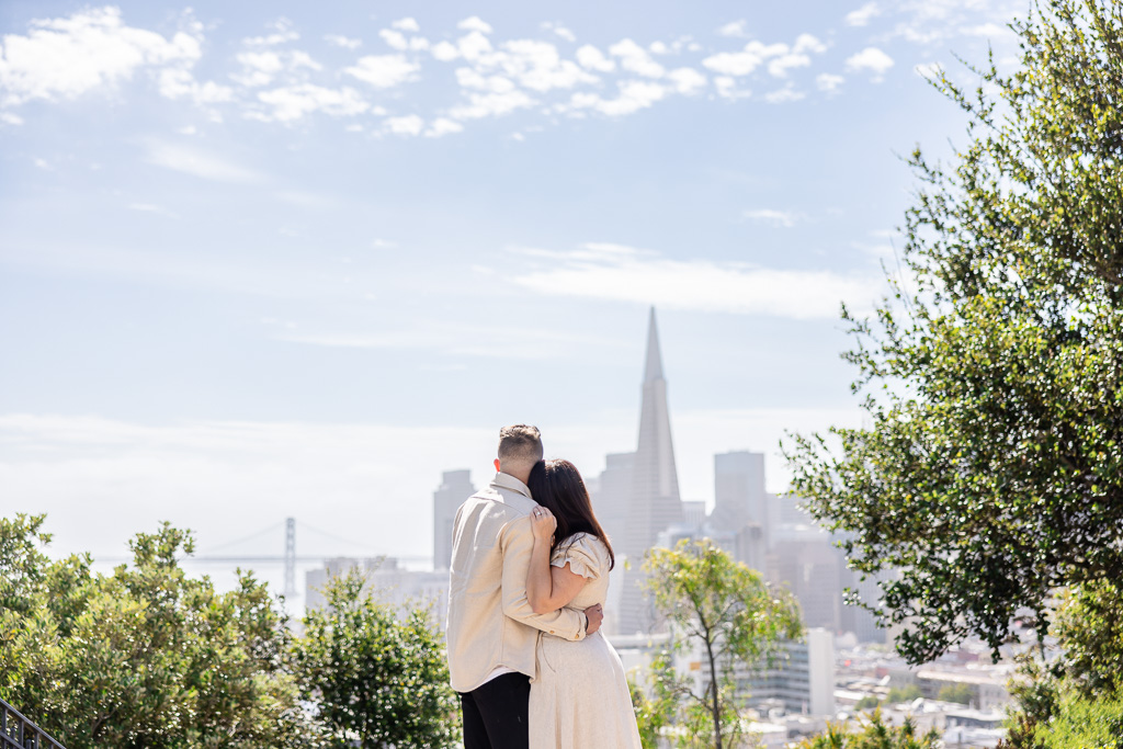 couple leaning on shoulder back turned against camera looking at San Francisco skyline