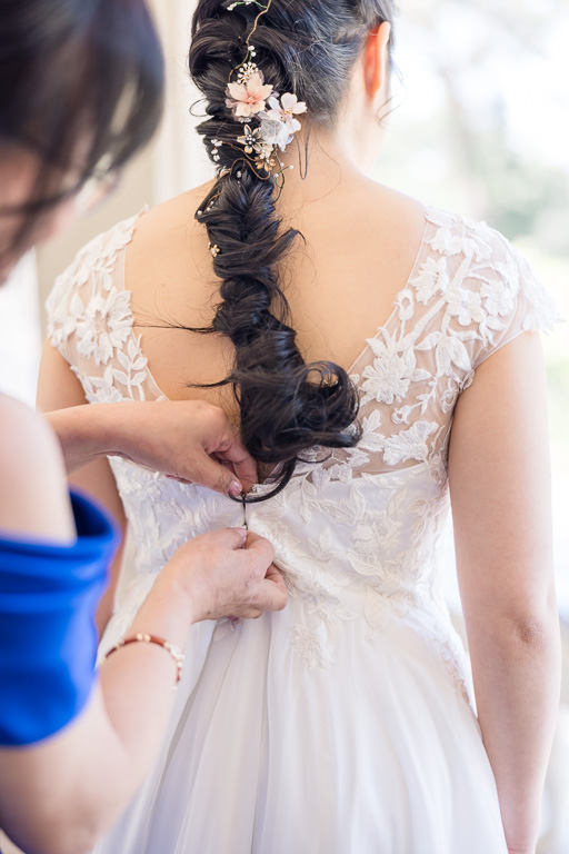 mother of the bride helping to zip up wedding dress