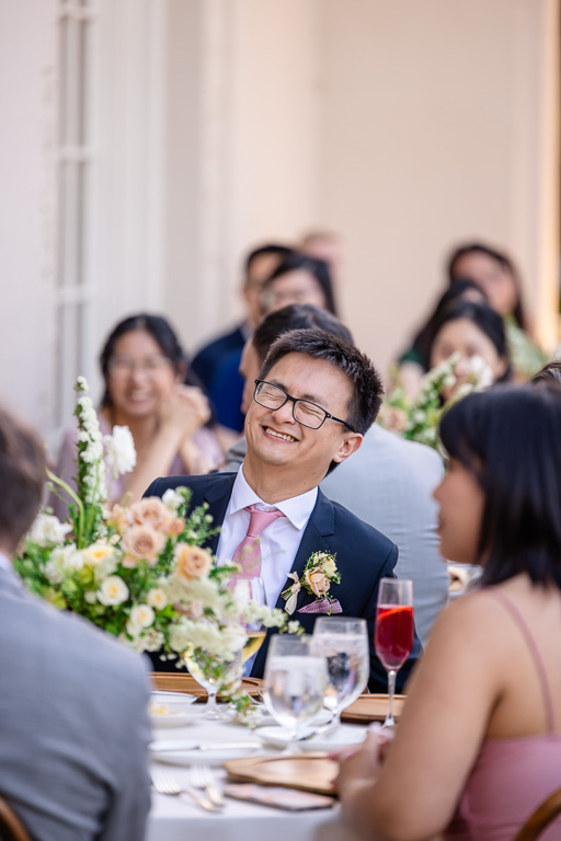 groomsman laughing during dinner speeches