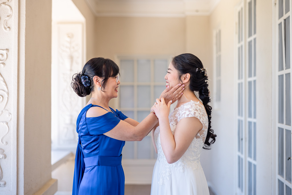 bride and her mom sharing a moment together before wedding