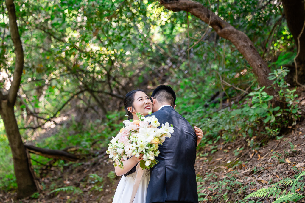 bride and groom having a first look in the woods