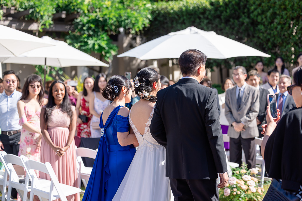 bride walking down the aisle with both of her parents