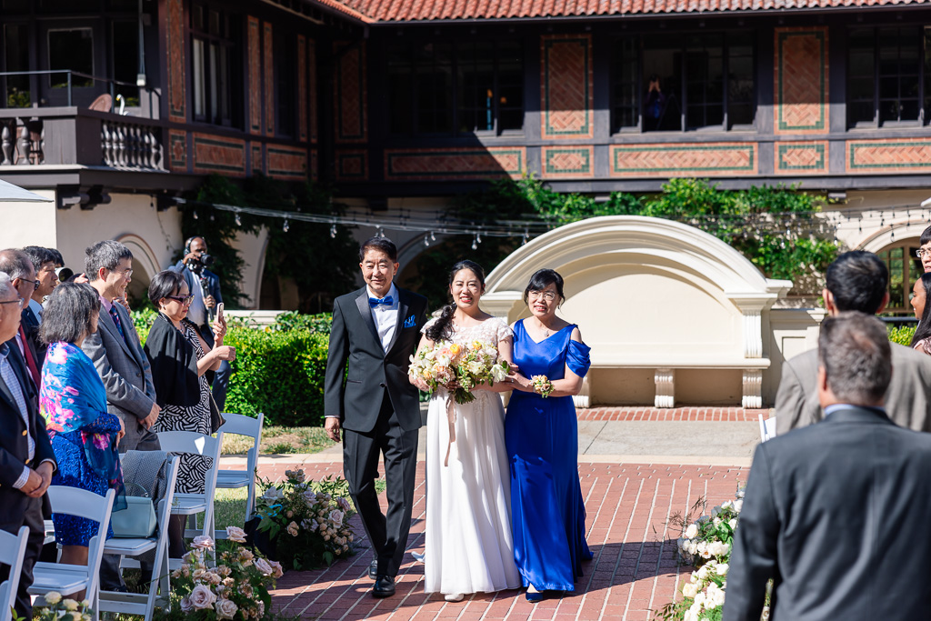 bride with her mom and dad walking down the aisle at the Montalvo Oval Garden