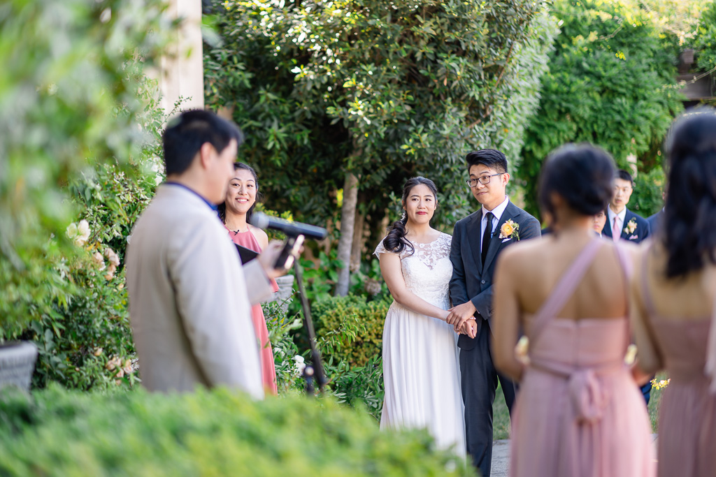 bride and groom listening to a guest give a speech during ceremony