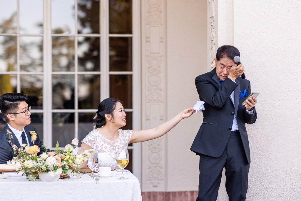 bride handing father a handkerchief to wipe a tear during his poignant speech