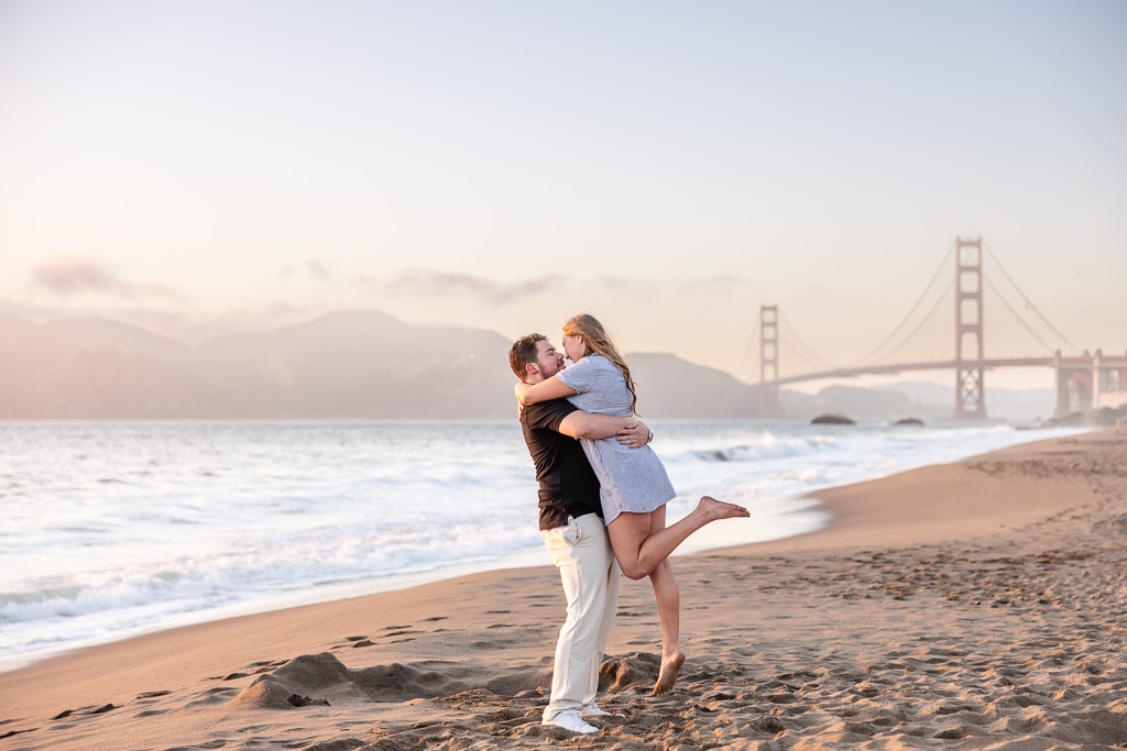 engagement photo embracing and lifting up at the Golden Gate Bridge