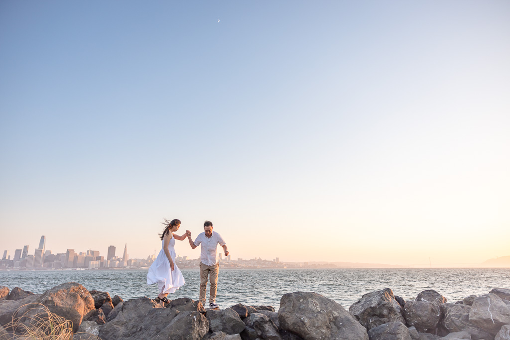 candid engagement photo style on the Bay with a view of the SF skyline