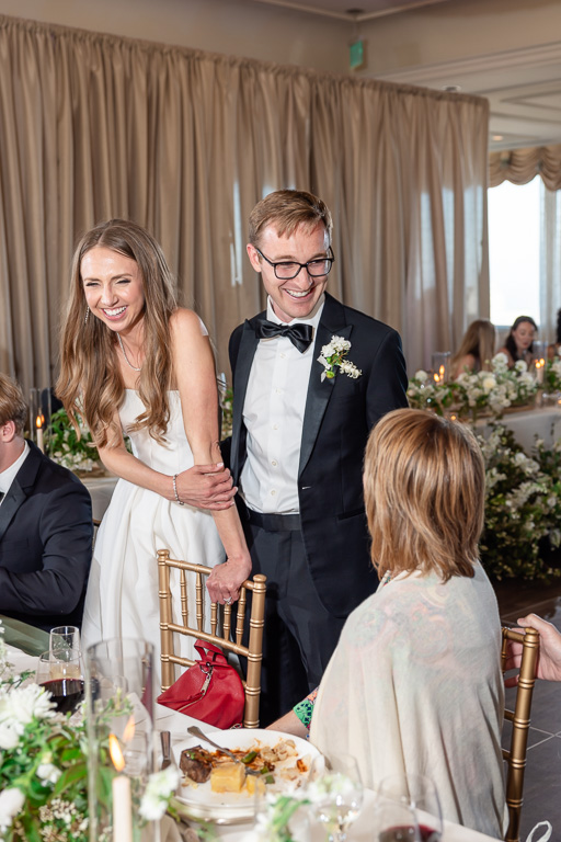 a cute moment of the bride and groom visiting tables