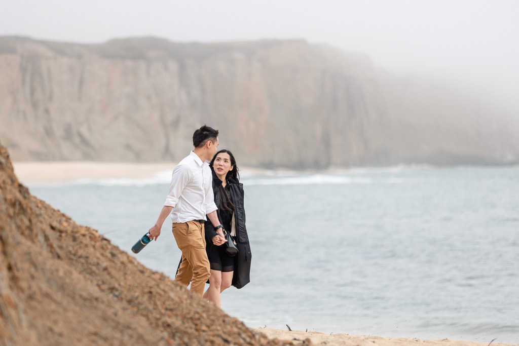 couple rounding a corner on the beach