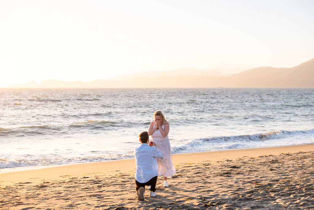 surprise engagement on the beach at sunset