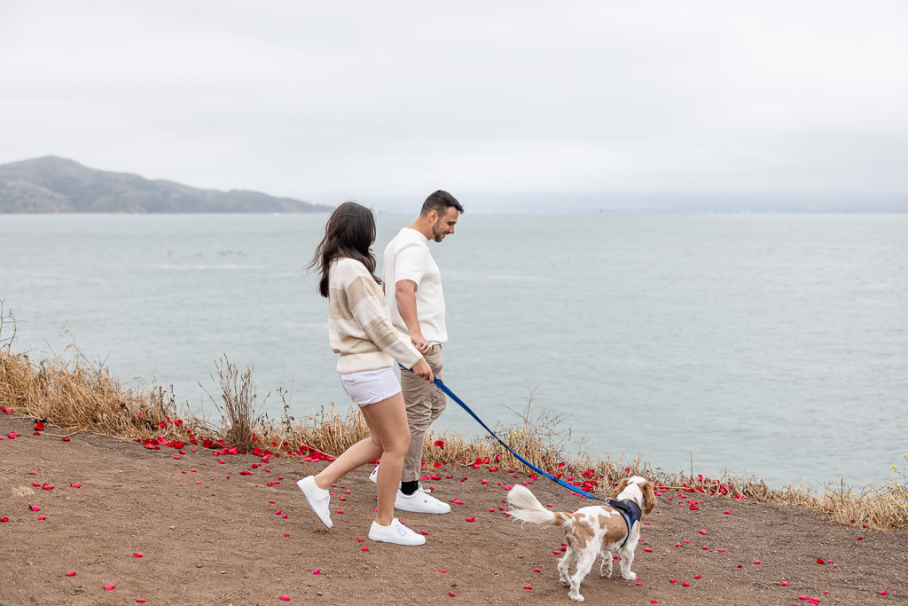 couple walking with their dog along the San Francisco Bay