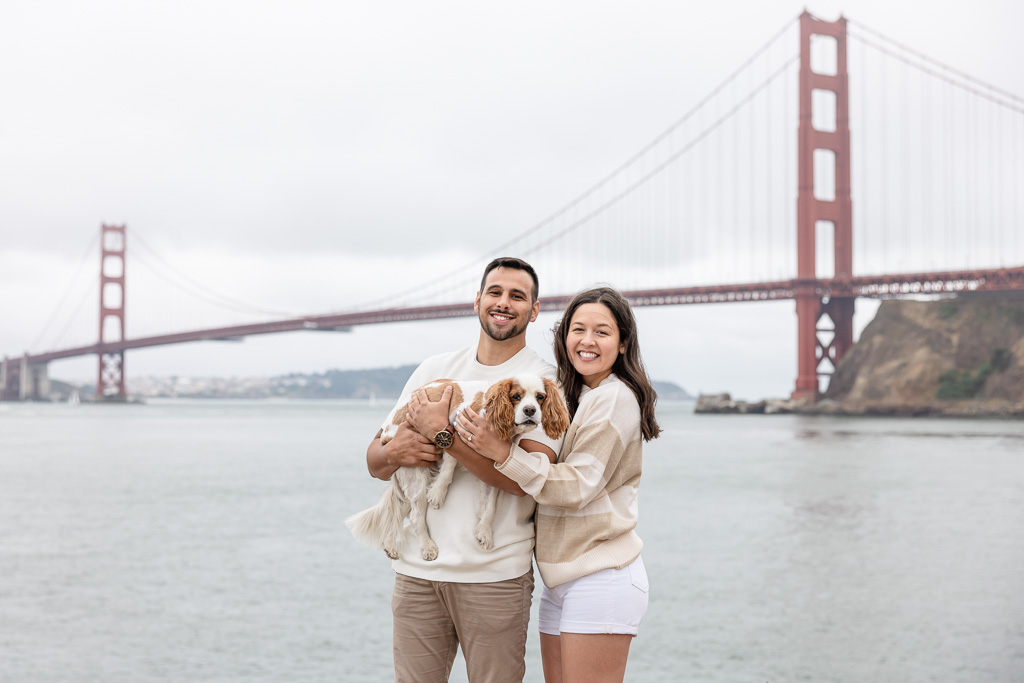 a couple photo with their dog in front of the Golden Gate Bridge