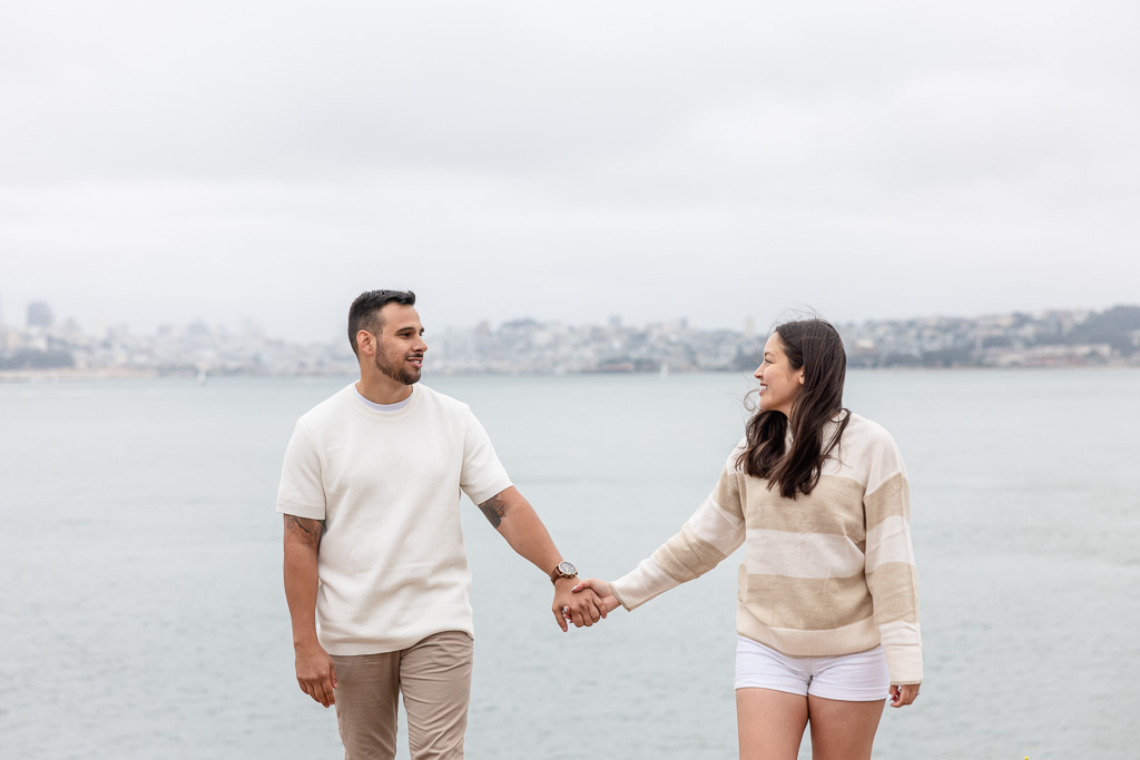 candid engagement shoot on the San Francisco Bay with the city in the background