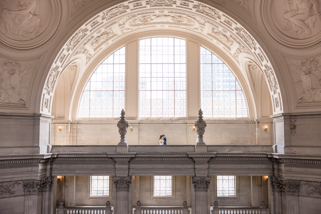 wedding portrait on the fourth floor of SF City Hall against giant window backdrop