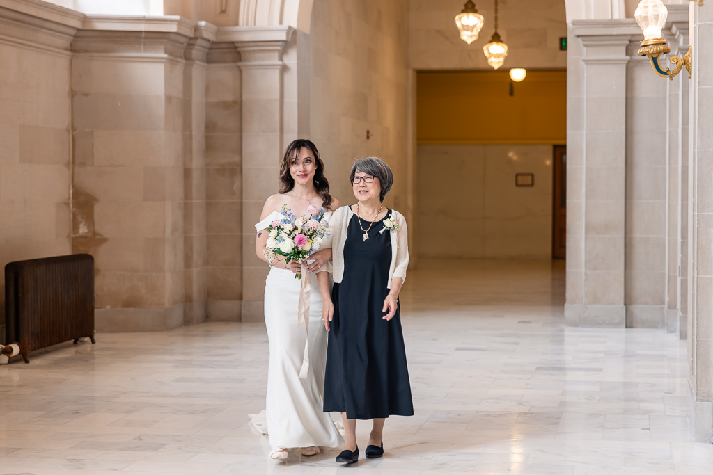 bride walking in to ceremony with mother