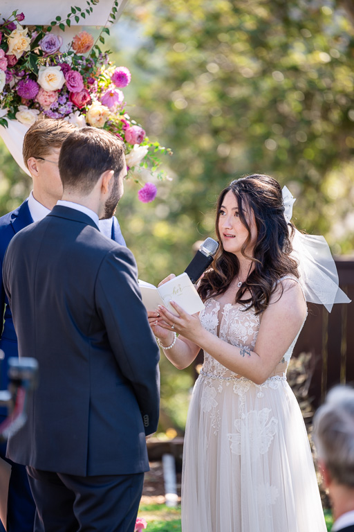 bride saying her handwritten vows during wedding ceremony