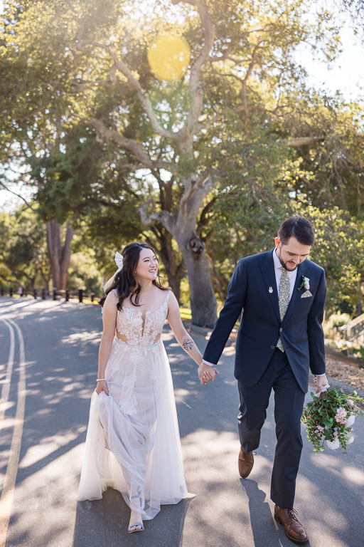 dreamy photo of bride and groom walknig in the sunset in front of some trees