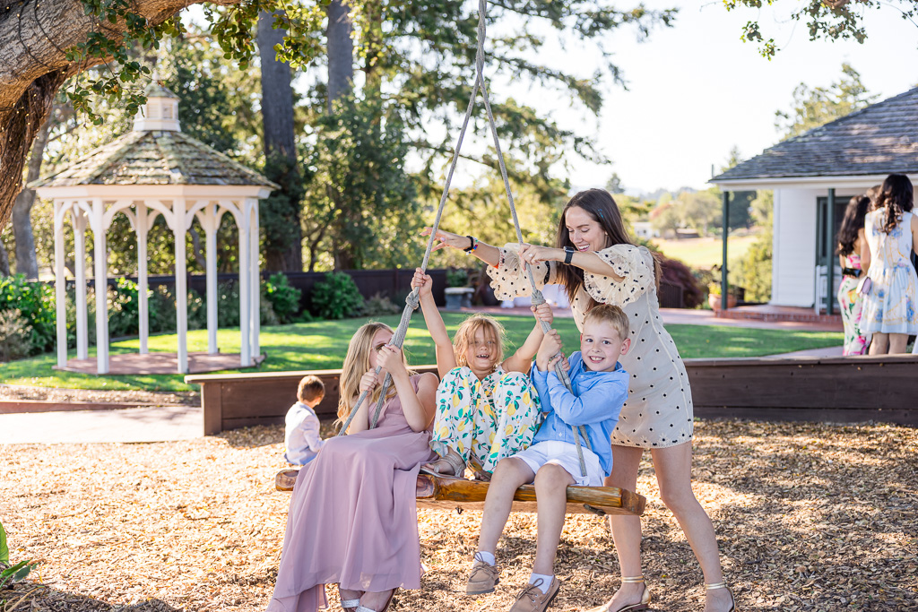 some guests and kids having fun on wooden swing