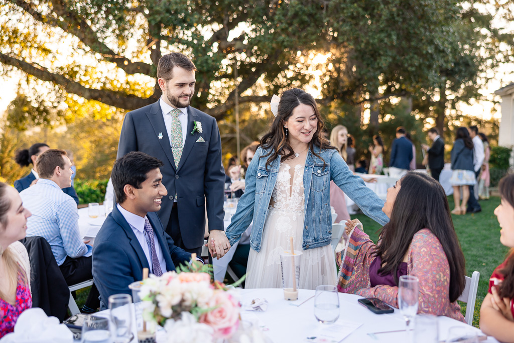 bride and groom visiting reception tables