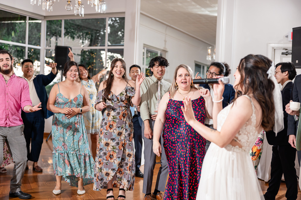 bride singing karaoke with all the guests at wedding reception