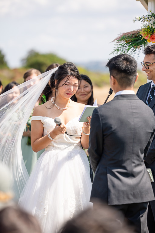 bride crying as she reads her vows to her groom