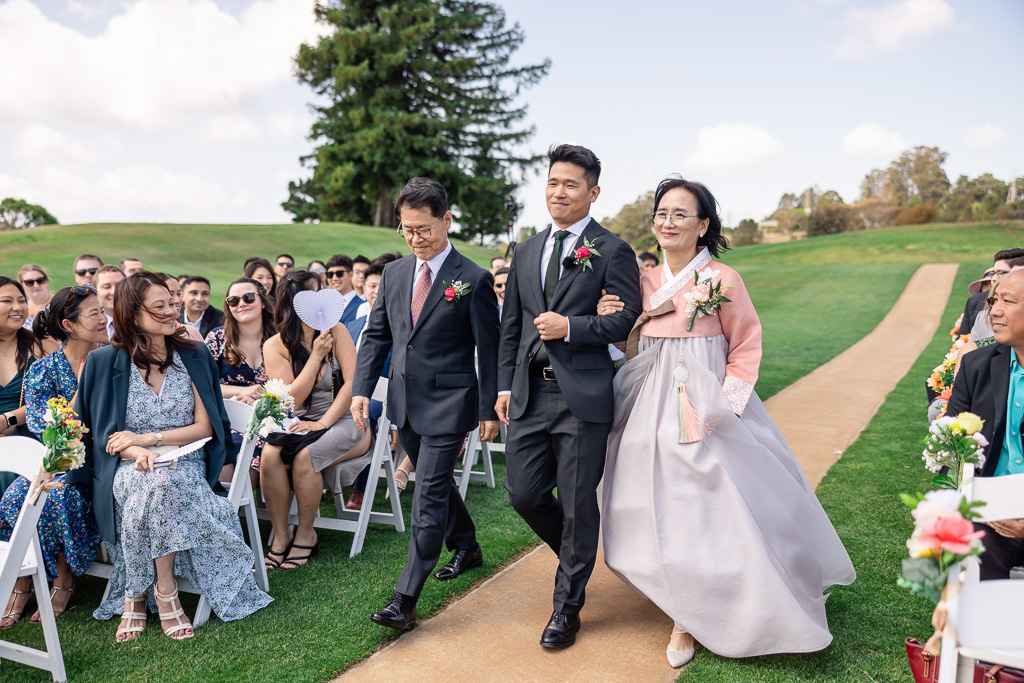 groom walking down the aisle with both parents