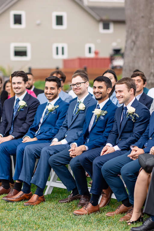 happy groomsmen seated in the front row