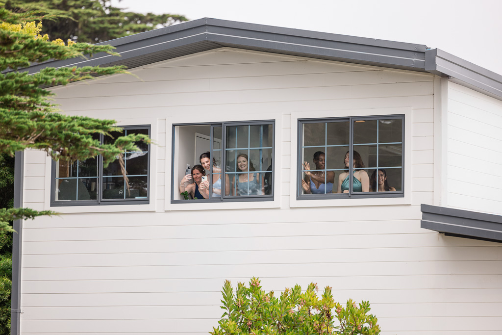 bridesmaids watching first look from second story window