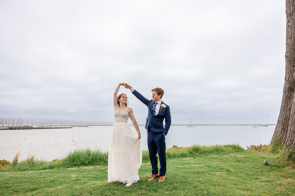 bride and groom dancing next to the ocean