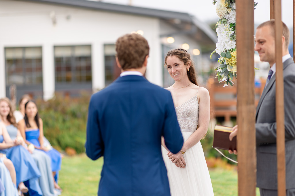 bride looking at groom while he gives his vows