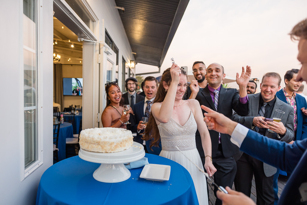 everyone laughing after the bride broke the cake cutting knife