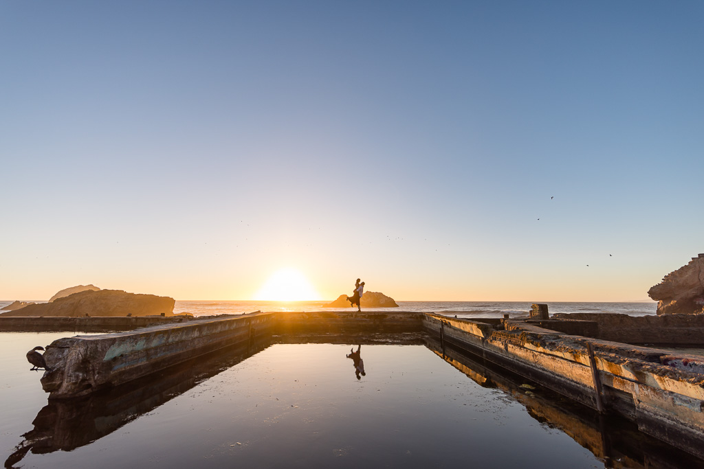 silhouette engagement photo with a dramatic sunset at Sutro Baths