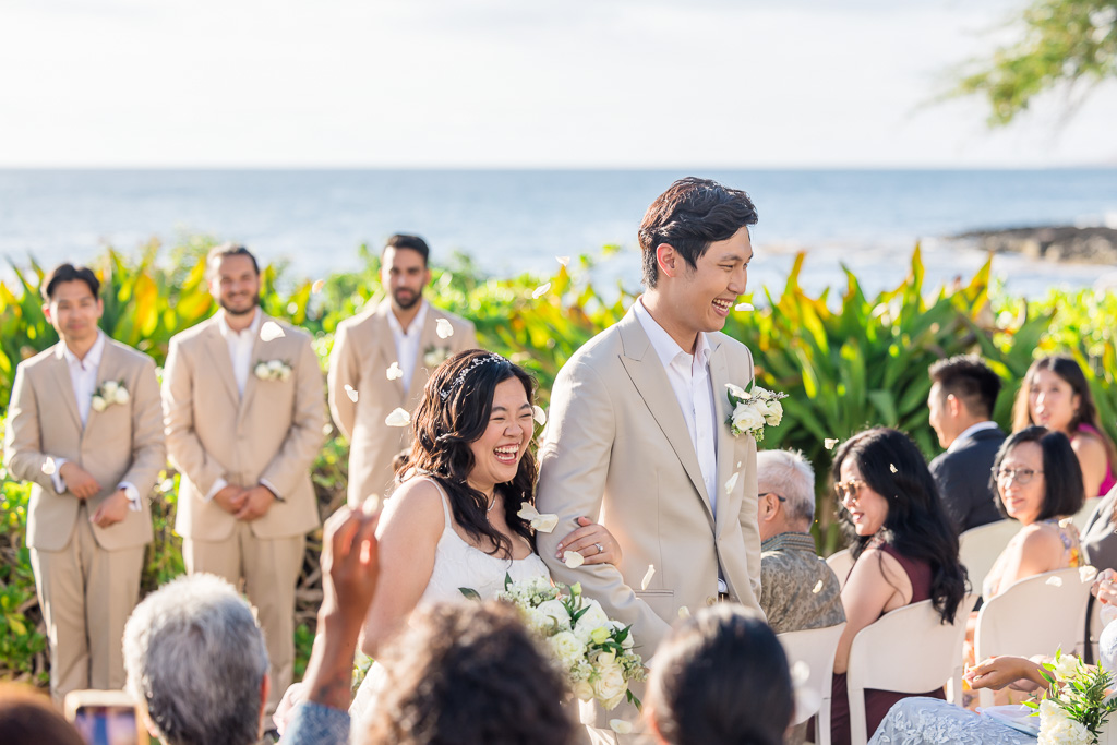 walking back down the aisle and getting flower petals tossed on them