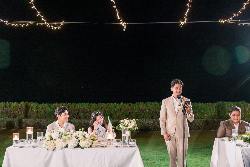 bride wiping away a tear during dinner toasts