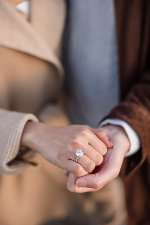 close-up of hands and diamond engagement ring