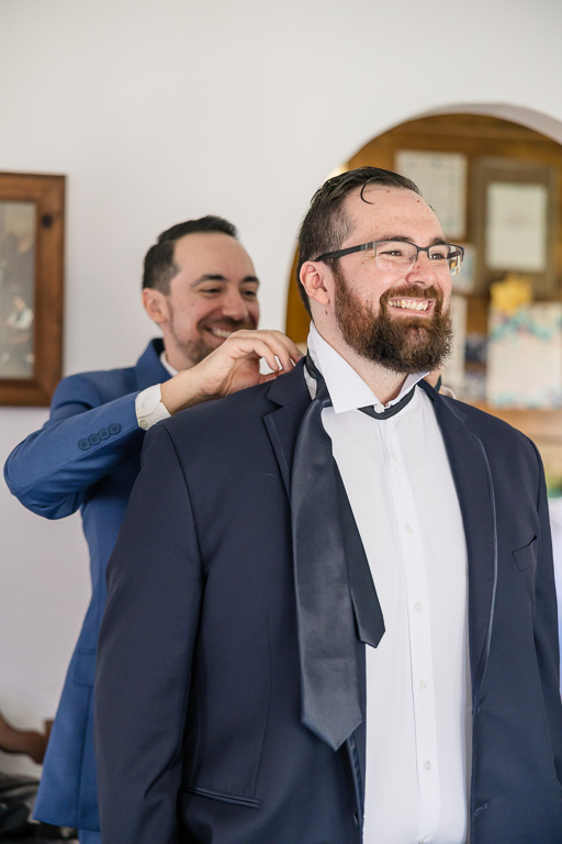 best man helping his brother put on his tie