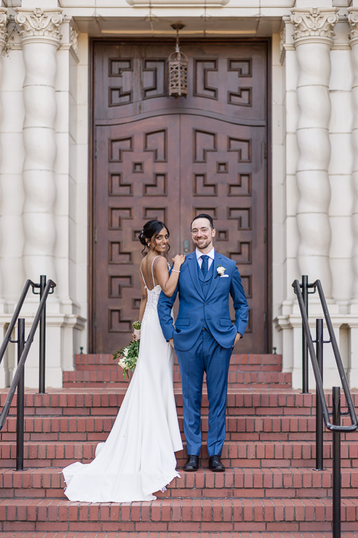 wedding photo in front of the big wooden door at the Presidio Chapel