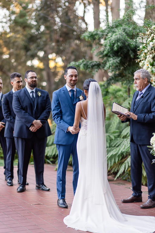 groom lovingly looking at his bride during their wedding ceremony in the outdoor garden at Golden Gate Club