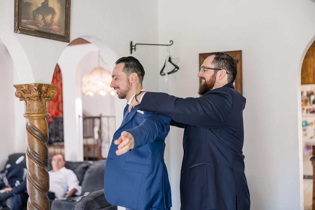 best man helping groom with his jacket