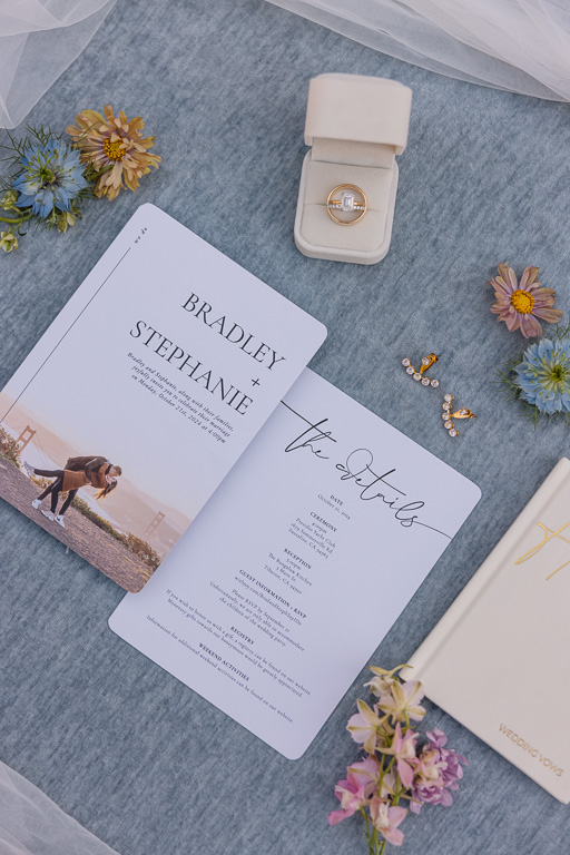 wedding invitation, rings, earrings flat lay