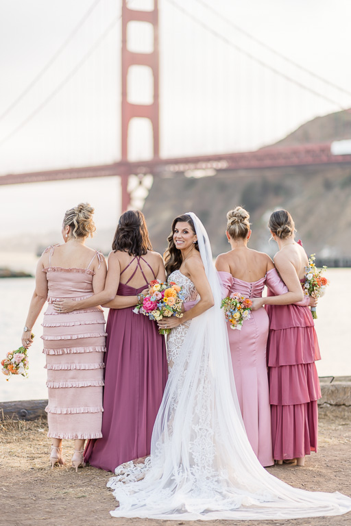 bride and bridesmaids at the Bay water under the Golden Gate Bridge