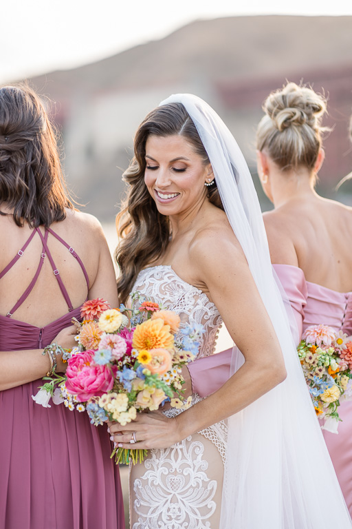 bride with bridesmaids showing colorful wedding bouquet