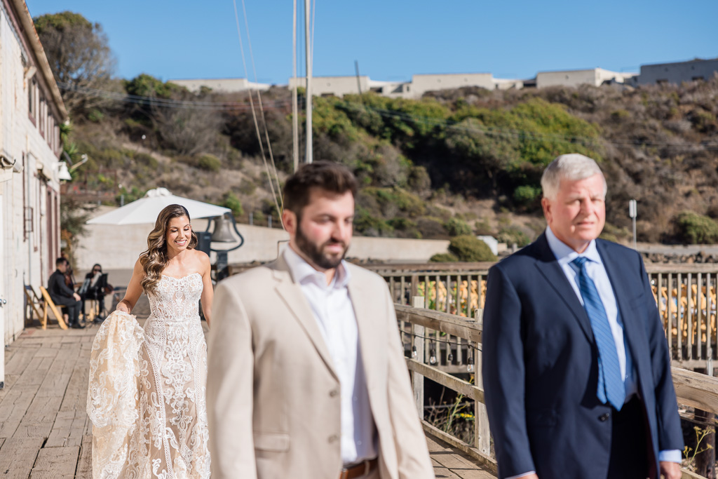 bride walking up to her dad and brother for a first look