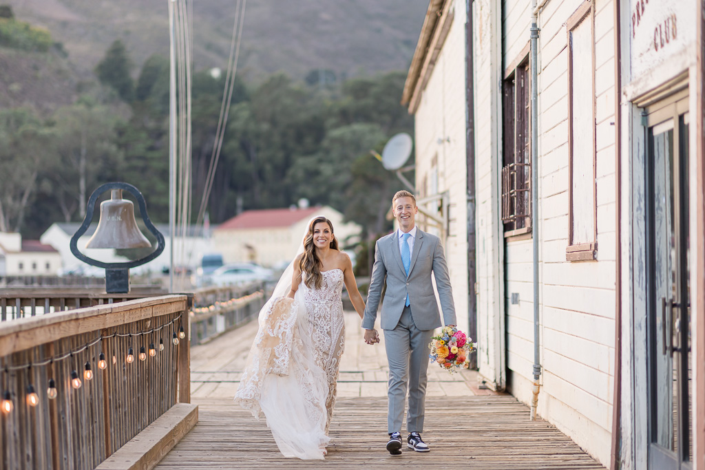 bride and groom walking along the marina