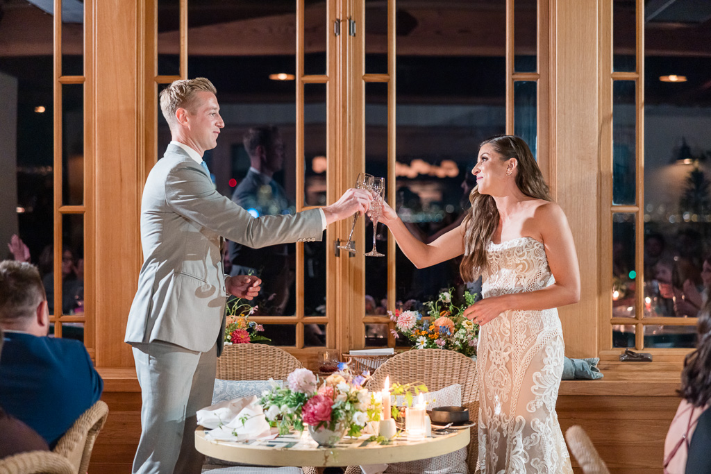 bride and groom cheers over sweetheart table