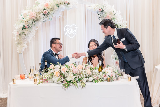 groomsman shaking the groom's hand after giving a toast