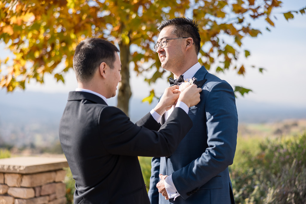 boutonniere pinning on groom in San Jose in the fall